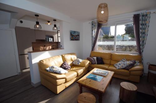 un salon avec un canapé et une table dans l'établissement Villa Quiné Plage, à Quinéville