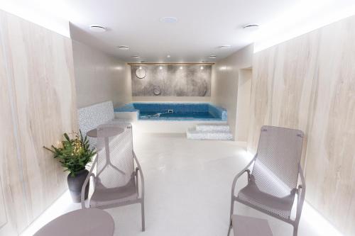 a bathroom with two chairs and a tub at Forest Hill Hotel & SPA in Bukovel