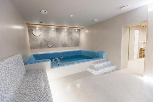 ein Bad mit einer blauen Badewanne in einem Zimmer in der Unterkunft Forest Hill Hotel & SPA in Bukowel