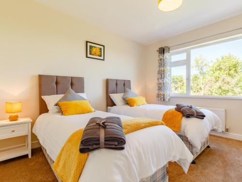 2 camas en un dormitorio con ventana en 3 bed property in Bude 78213 en Ashwater