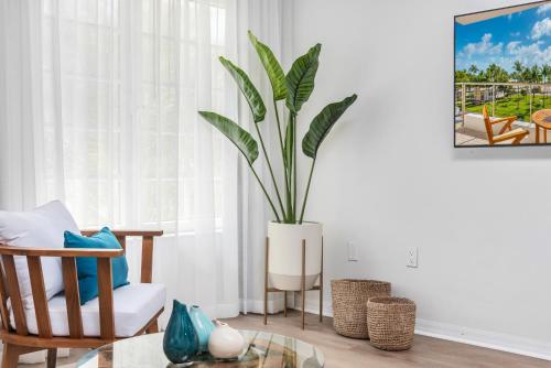a plant in a white vase in a living room at Bentley Hotel South Beach in Miami Beach