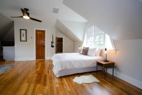 Schlafzimmer mit einem weißen Bett und einem Deckenventilator in der Unterkunft Captivating Cowgirl in Denver