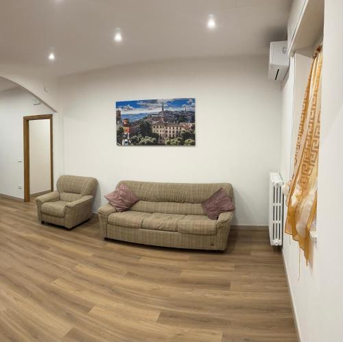a living room with two couches and a painting on the wall at la casa della nonna in Collazzone