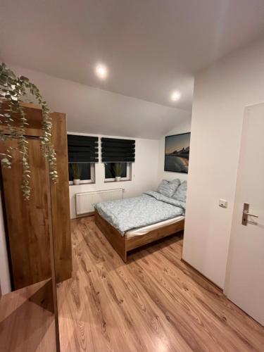een slaapkamer met een bed en 2 ramen bij Apartment Södderich 2 in Waake