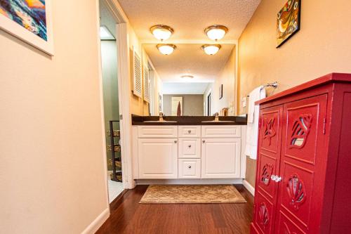 a bathroom with a red cabinet and a sink at Peaceful Pond Paradise III ~ Ground Floor ~ Water Views in Wesley Chapel