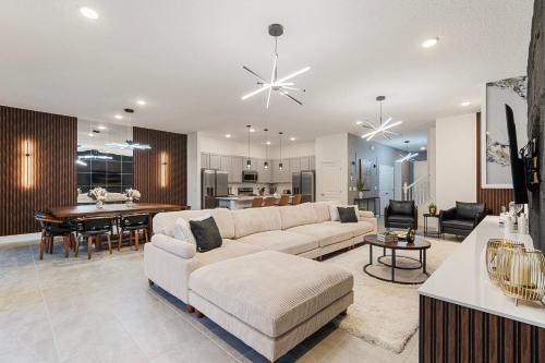 uma sala de estar com um sofá e uma mesa em Luxury Retreat in the Heart of IDrive 10bed 9Bath em Orlando