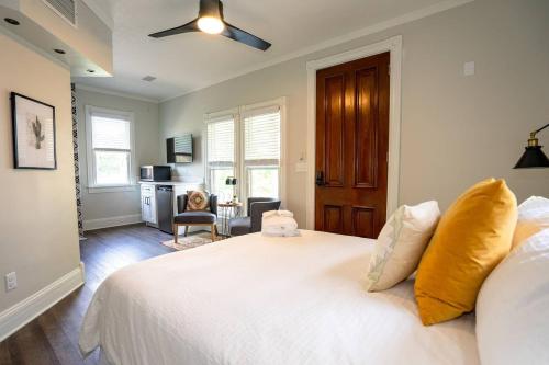 a bedroom with a white bed and a desk at The Charming Cowboy in Denver