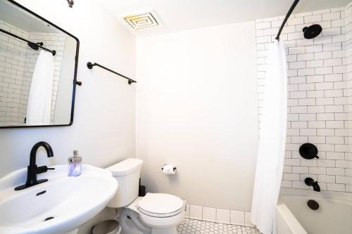 a white bathroom with a sink and a toilet at The Charming Cowboy in Denver