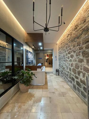 a living room with a stone wall and a chandelier at Holiday Inn Express Morelia Centro Historico in Morelia