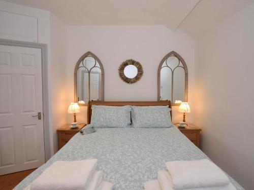 a bedroom with a bed with two lamps and a mirror at 1 bed in Pwllheli 60173 in Pwllheli