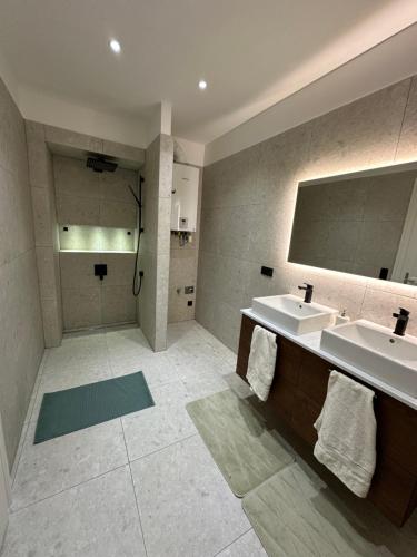 een badkamer met 2 wastafels en een douche bij Palais Living Suite in Wenen