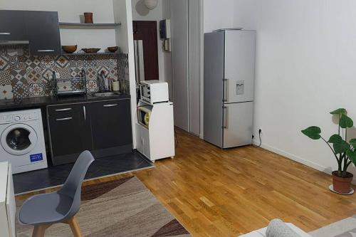 a kitchen with a refrigerator and a chair in a room at Paradise Studio in Pontault-Combault