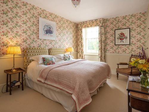 1 dormitorio con cama grande y papel pintado con motivos florales en Bell Flat - Uk42250 en Broughton