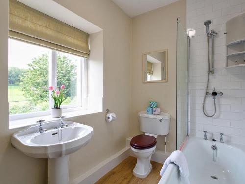 a bathroom with a sink and a toilet and a tub at Gargrave Cottage - Uk42248 in Broughton