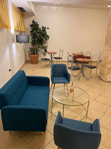 a room with two blue couches and a table and chairs at Hotel Vico Alto Siena in Siena