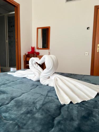 Una donna in bianco giace su un letto di Hotel Vico Alto Siena a Siena