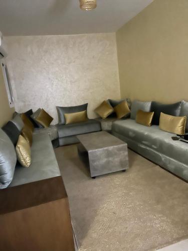 - un salon avec un canapé en cuir et des oreillers en or dans l'établissement مراكش جنان اوراد, à Marrakech