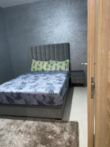 - une chambre avec un lit orné d'un mur gris dans l'établissement مراكش جنان اوراد, à Marrakech