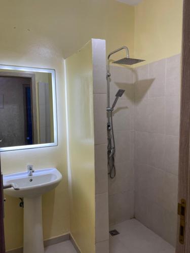 La salle de bains est pourvue d'un lavabo et d'une douche avec un miroir. dans l'établissement مراكش جنان اوراد, à Marrakech