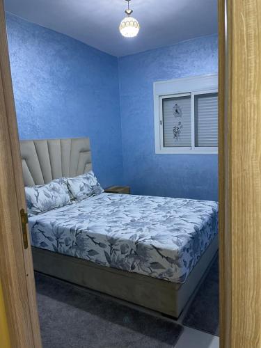 - une chambre avec un lit dans une pièce bleue dans l'établissement مراكش جنان اوراد, à Marrakech