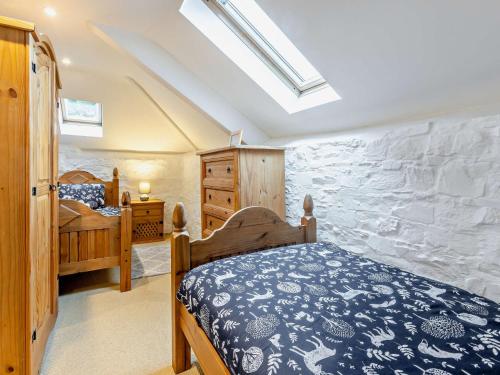 a bedroom with a bed and a stone wall at 3 Bed in Bude WVFCO in Ashwater
