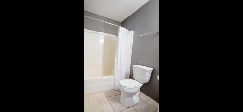 a bathroom with a white toilet and a shower at Family Friendly Home in walking district, 5 minutes from beach in Gulf Shores