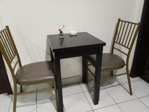 una mesa negra con dos sillas y un tazón en ella en HOTEL DORAL, en Guayaquil