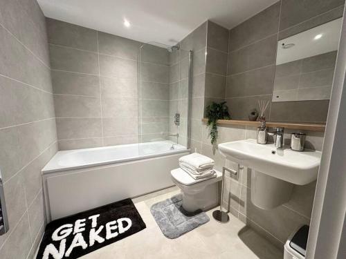 uma casa de banho com uma banheira, um WC e um lavatório. em Penthouse Flat in Manchester em Manchester