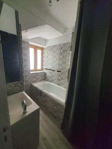 a bathroom with a bath tub and a sink at Maison Isola Village in Isola