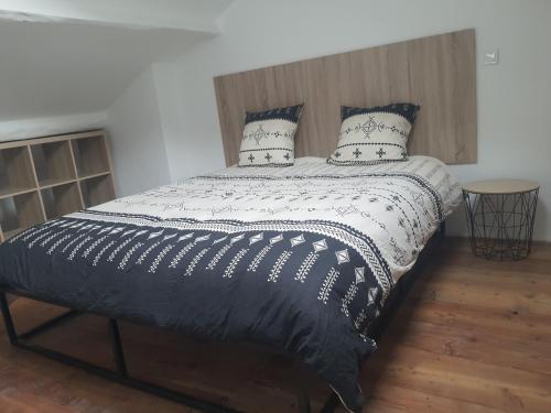 un letto con piumone e cuscini in bianco e nero di Maison Isola Village a Isola