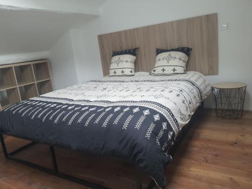 a bed with a black and white comforter and pillows at Maison Isola Village in Isola