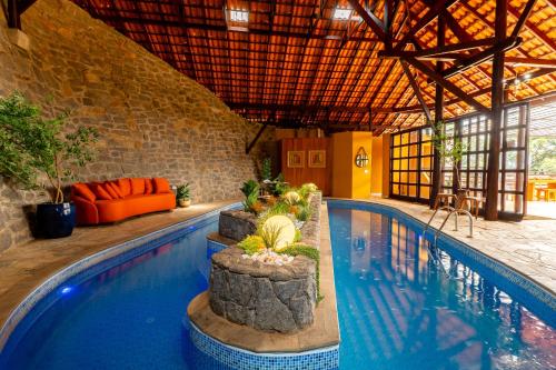 a swimming pool in a building with a pool at Pousada Cerejeiras in Monte Verde
