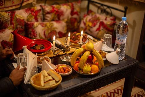 a table topped with plates of food and candles at Riad Soultan in Fès
