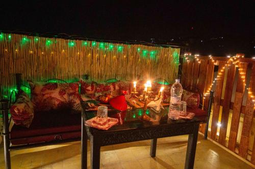 a table with candles and a couch on a patio with lights at Riad Soultan in Fès
