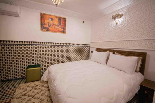 a bedroom with a large white bed in a room at Riad Soultan in Fès