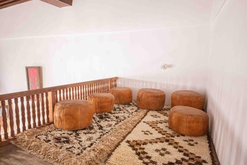 a room with four ottomans and four stools at Riad Soultan in Fès
