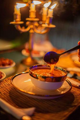 a bowl of soup on a table with a spoon at Riad Soultan in Fès