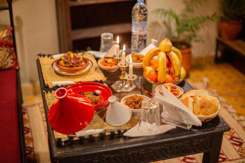 a table filled with dishes of food and candles at Riad Soultan in Fès