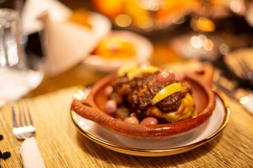 a bowl of food on a plate on a table at Riad Soultan in Fès