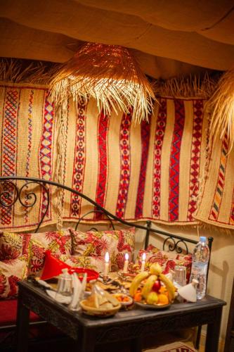 a table with plates of food and candles on it at Riad Soultan in Fès