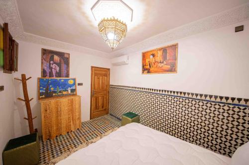 a bedroom with a bed and a chandelier at Riad Soultan in Fès