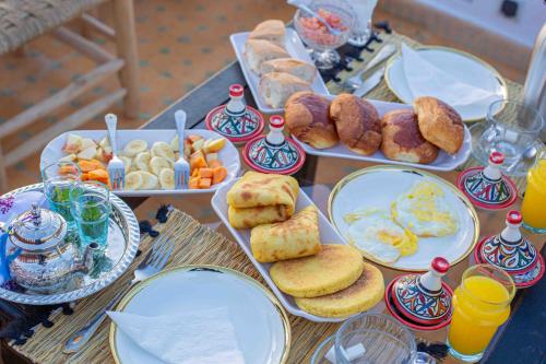 a table with plates of breakfast foods and drinks at Riad Soultan in Fès