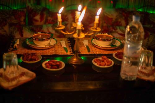 a table with plates of food and candles on it at Riad Soultan in Fès
