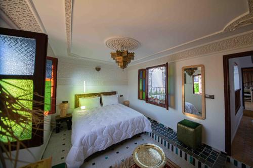 a bedroom with a bed and a chandelier at Riad Soultan in Fès