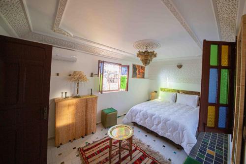 a bedroom with a bed and a chandelier at Riad Soultan in Fès