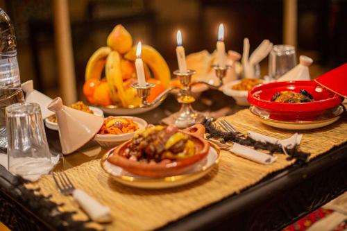 a table with plates of food and candles on it at Riad Soultan in Fès