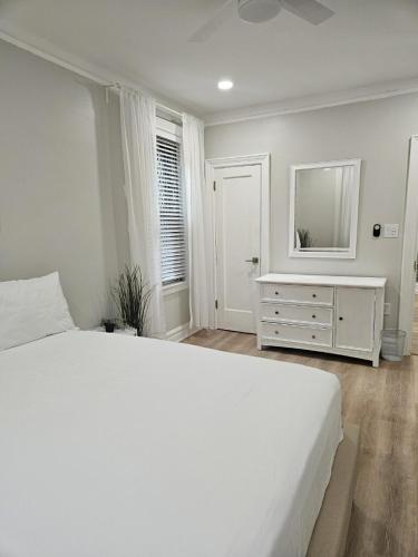 a bedroom with a white bed and a dresser with a mirror at Brooklyn retreat 1 in Brooklyn