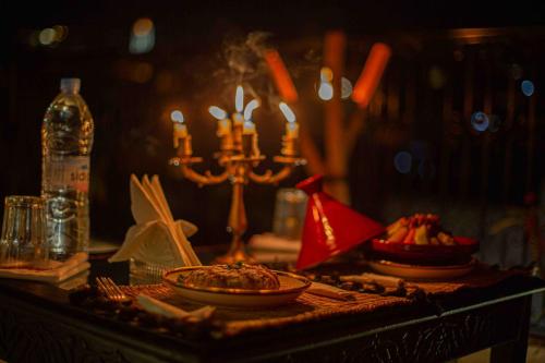 a table with plates of food and candles on it at Riad Soultan in Fès