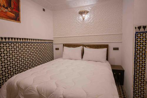 a bedroom with a large white bed in a room at Riad Soultan in Fès