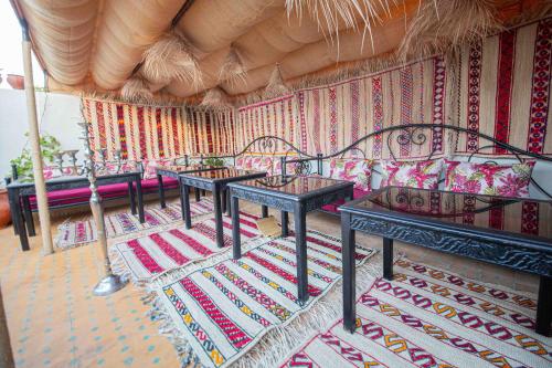 a room with several tables and benches in a room at Riad Soultan in Fès